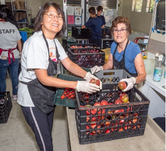 Food pantry employee Yvette and volunteer Karen sorting produce